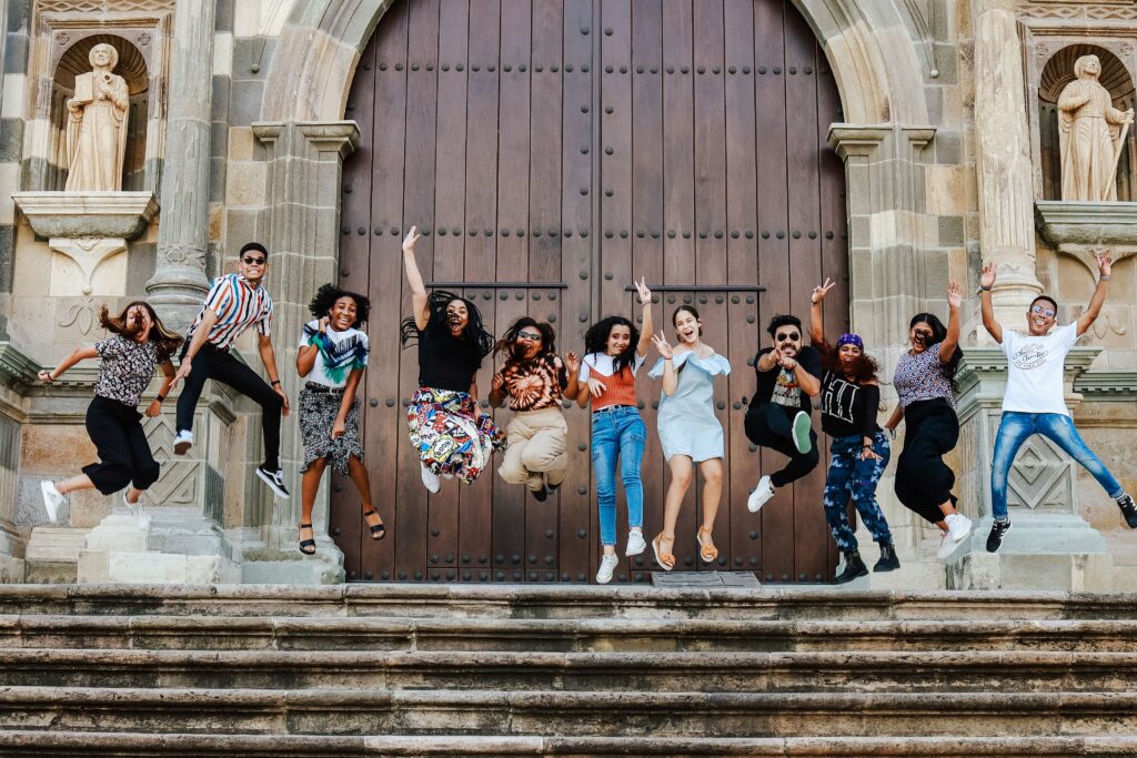 pexels photo 17664540 17664540 1 A lively group of friends joyfully jumping on steps outside a historic cathedral.